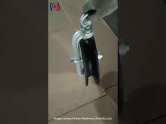 La cinghia tonda della linea aerea tiene premuto il blocco di tesatura della puleggia del cavo metallico